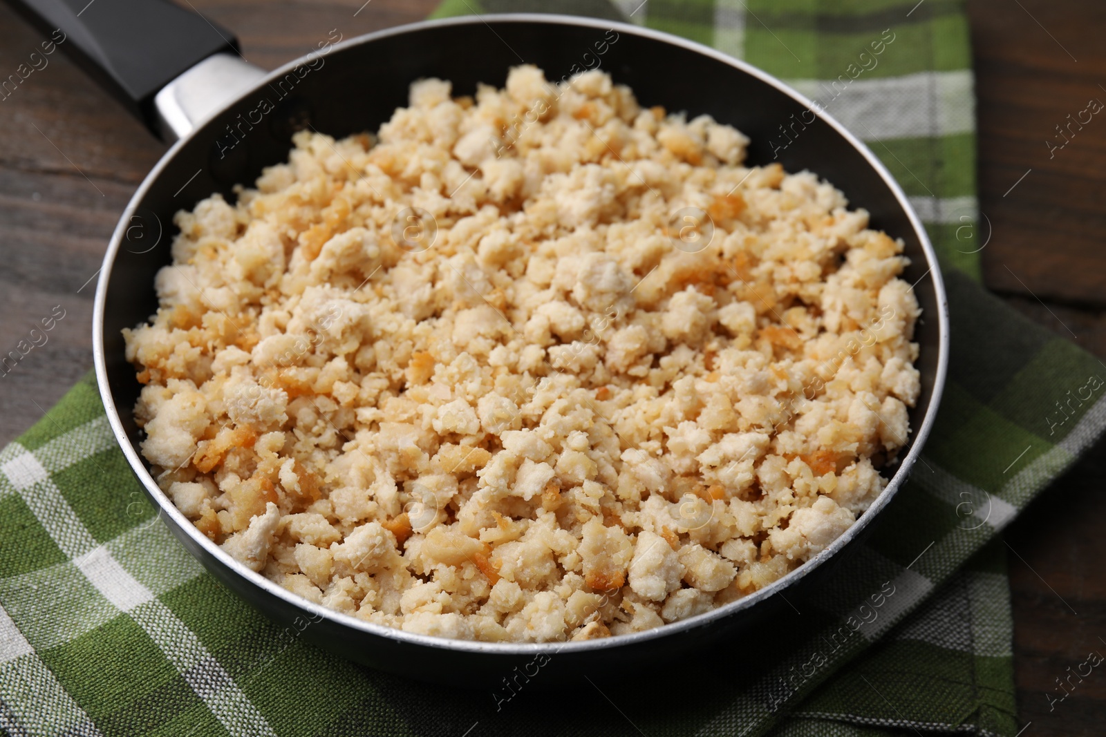 Photo of Fried ground meat in frying pan on wooden table, closeup