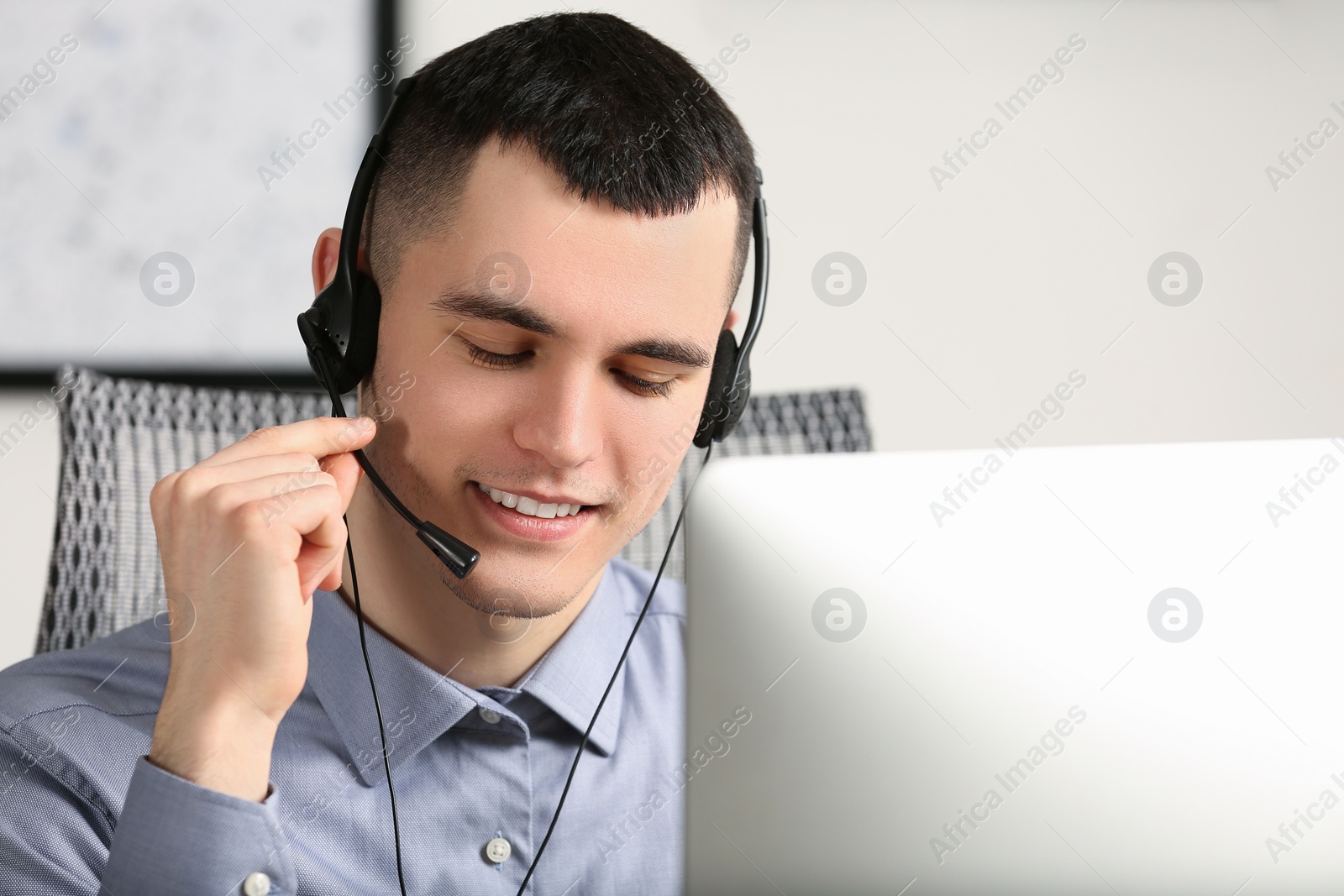 Photo of Hotline operator with headset working in office