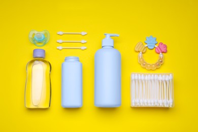 Flat lay composition with baby care products and accessories on yellow background