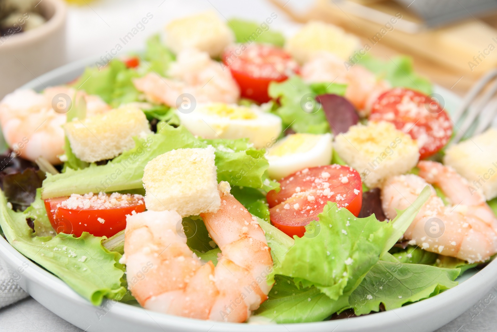 Photo of Delicious Caesar salad with shrimps on table, closeup