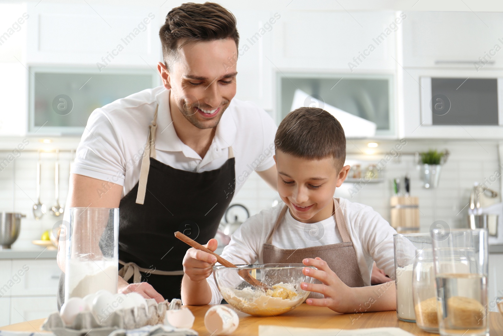 Photo of Dad and son cooking together in kitchen