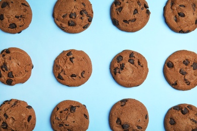 Delicious chocolate chip cookies on color background, flat lay