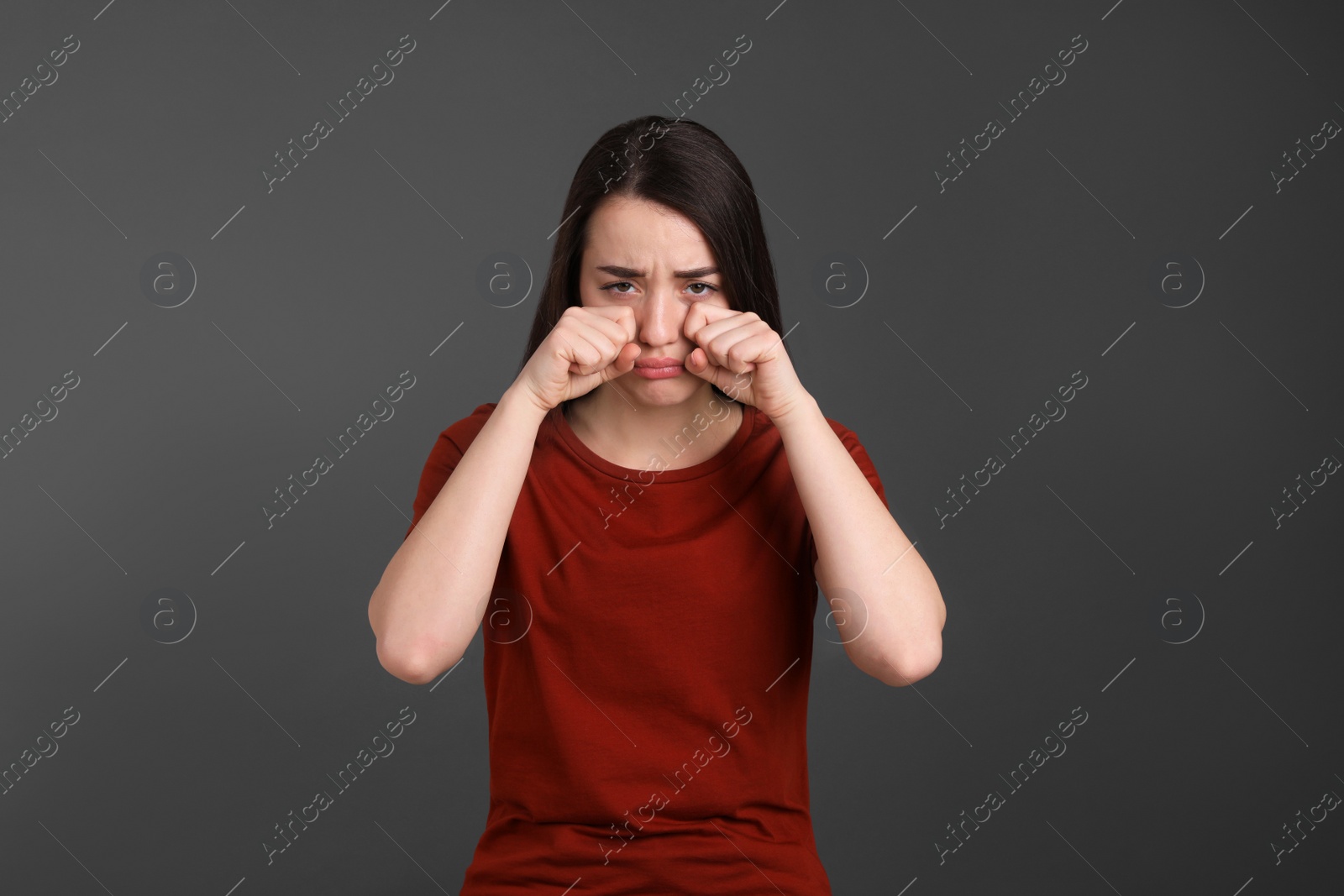 Photo of Portrait of emotional young woman on dark grey background. Personality concept