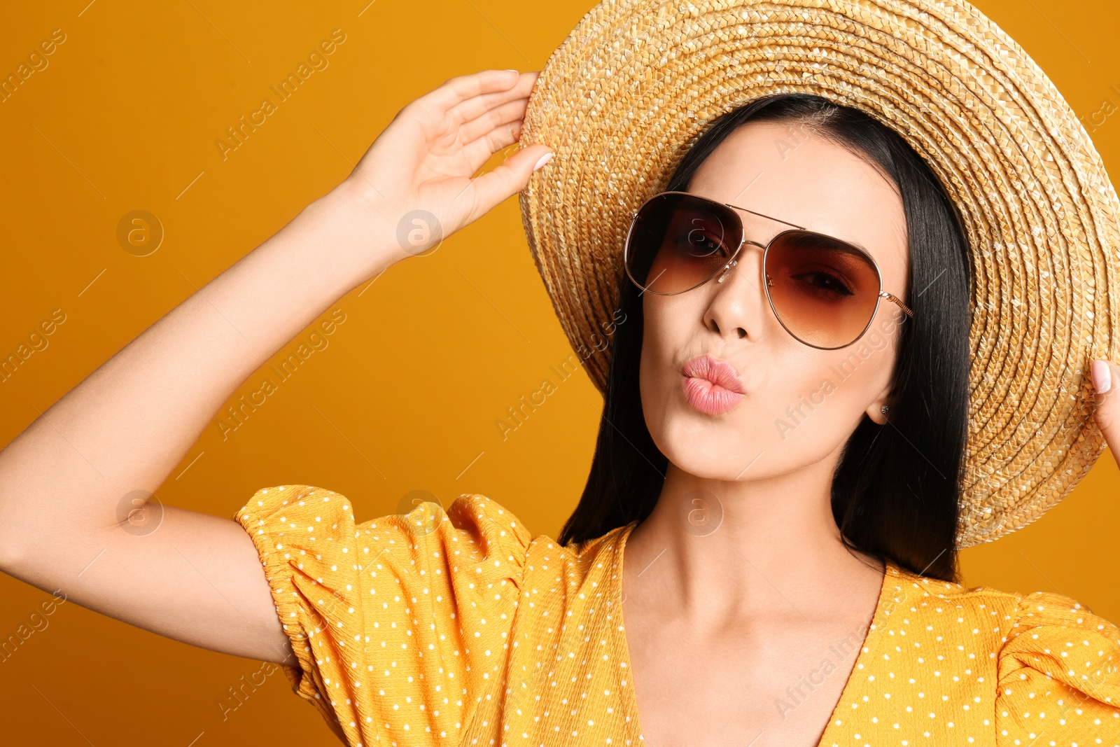 Photo of Beautiful woman wearing sunglasses on yellow background