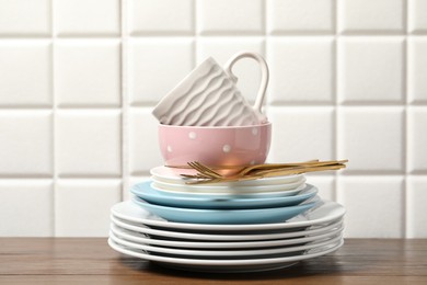 Photo of Beautiful ceramic dishware, cup and cutlery on wooden table