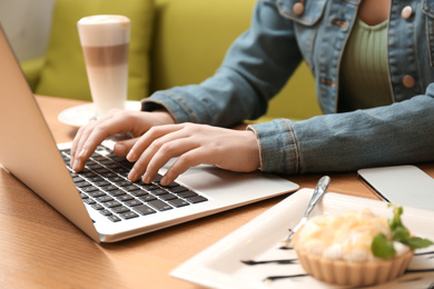 Photo of Blogger working with laptop in cafe, closeup