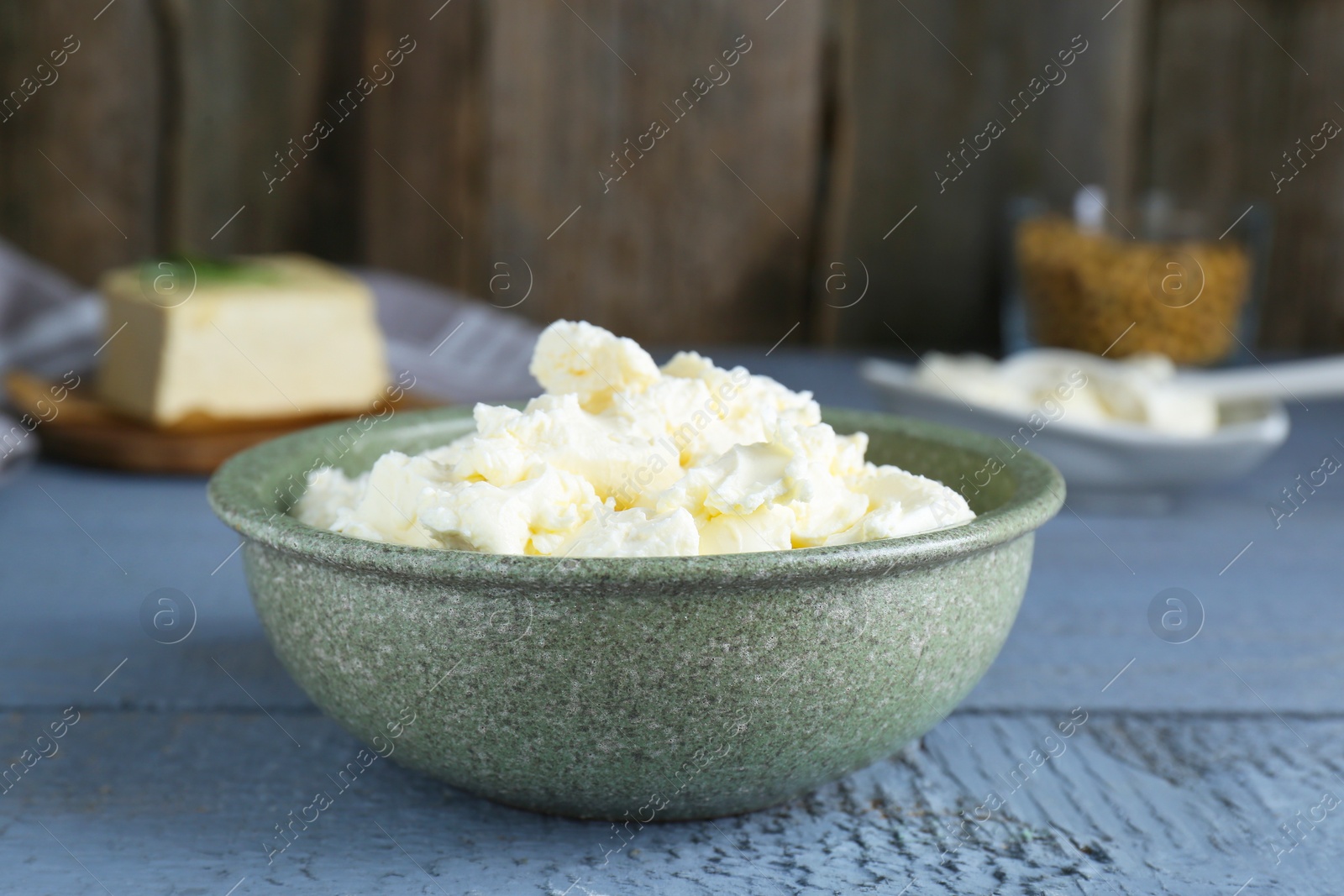 Photo of Delicious tofu cream cheese in bowl on grey wooden table