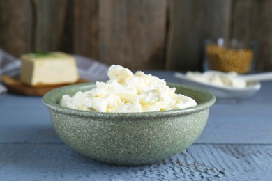 Photo of Delicious tofu cream cheese in bowl on grey wooden table