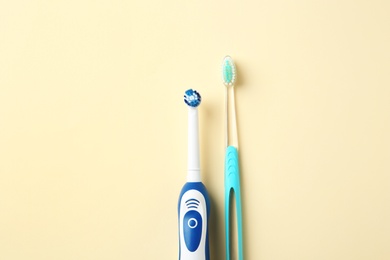 Photo of Manual and electric toothbrushes on color background. Dental care