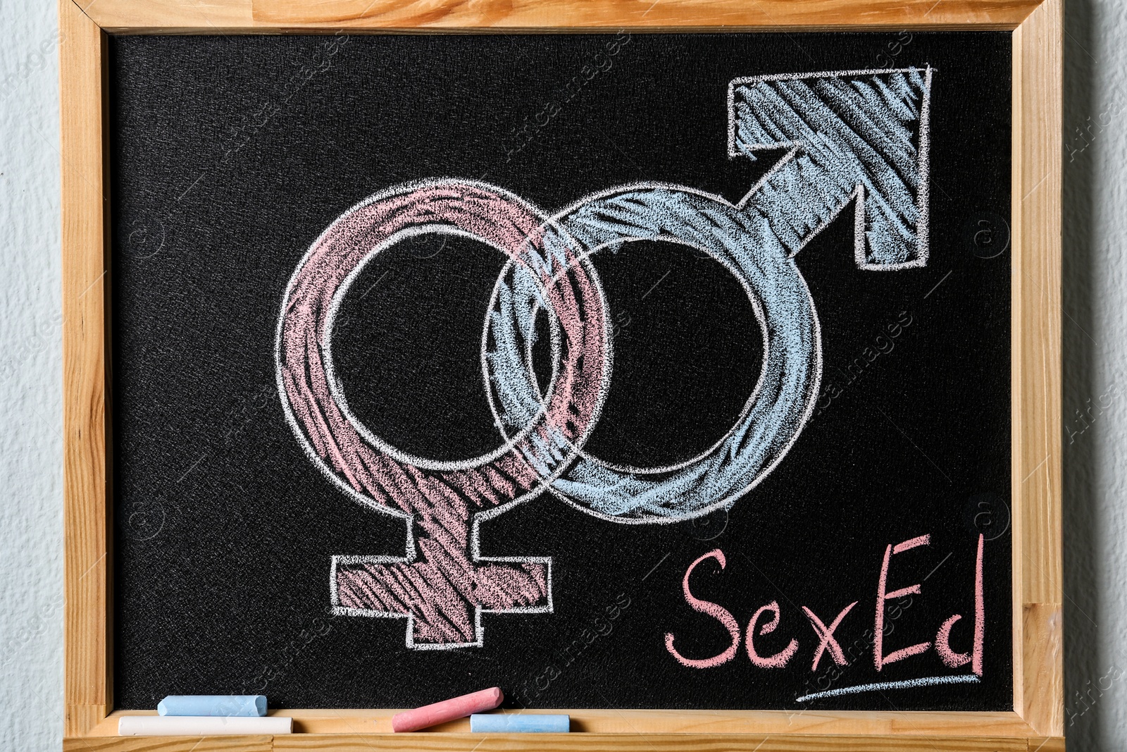 Photo of Gender symbols and text "SEX ED" written on small blackboard