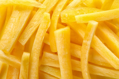 Photo of Raw yellow carrot sticks as background, closeup