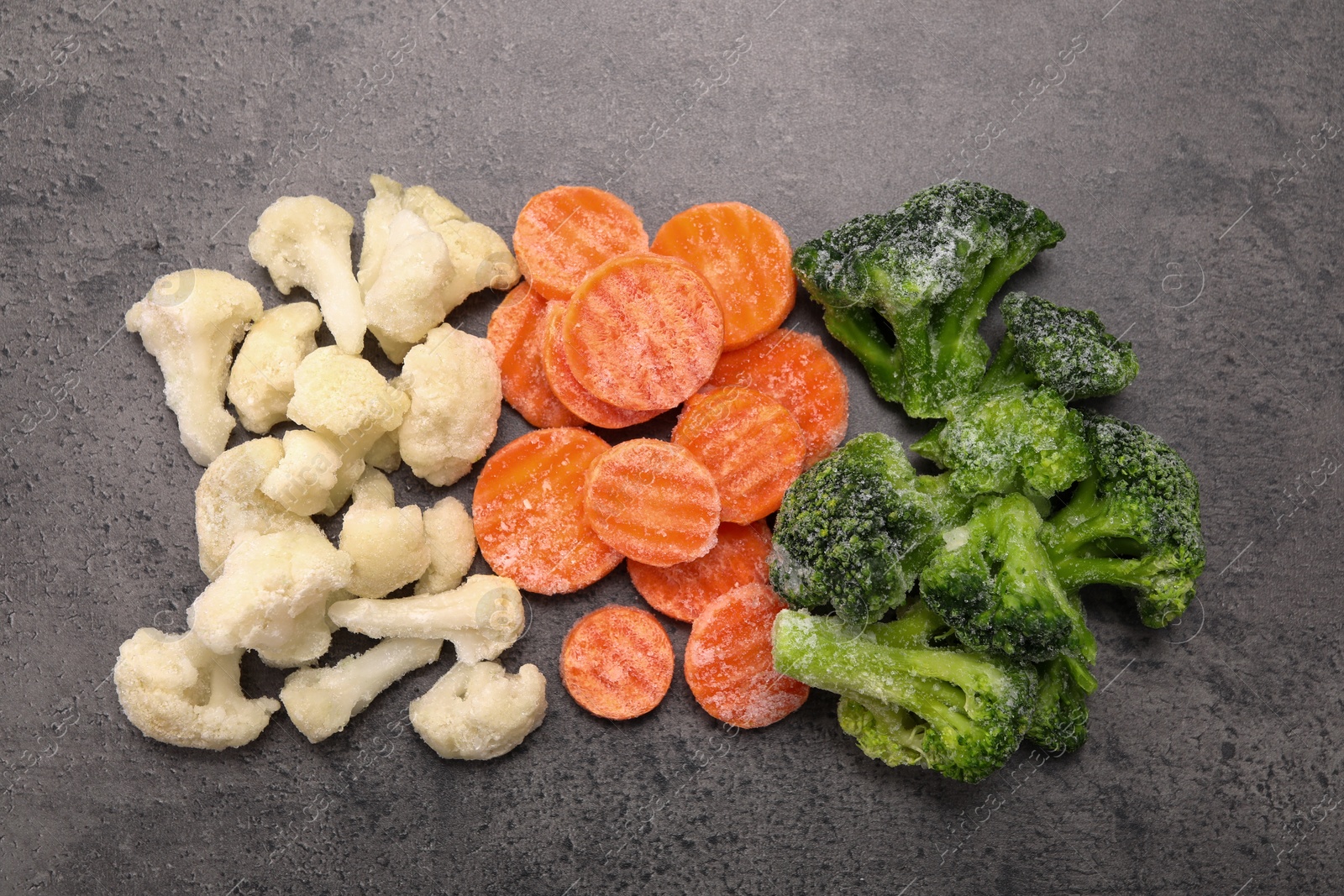 Photo of Different frozen vegetables on grey table, flat lay