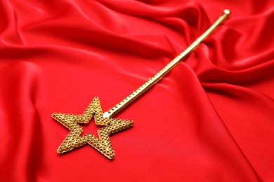 Beautiful golden magic wand on red fabric