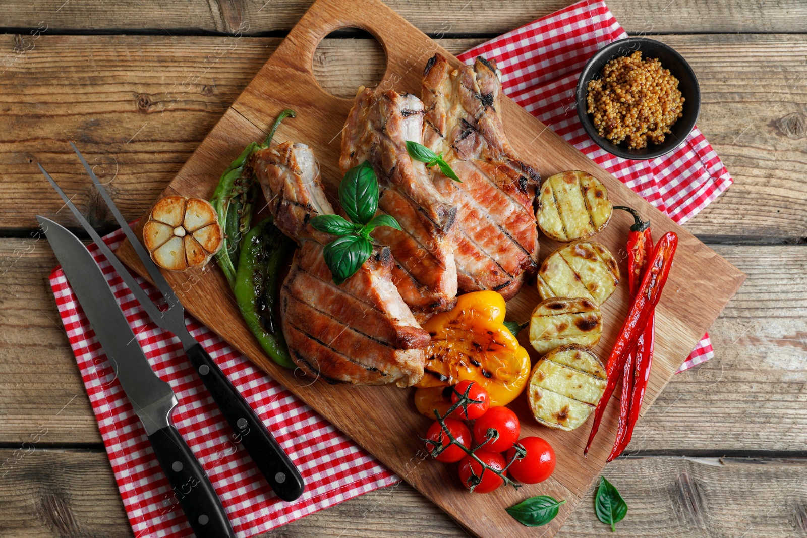 Photo of Delicious grilled meat and vegetables served on wooden table, flat lay