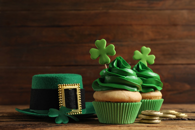 Photo of Composition with delicious decorated cupcakes on wooden table. St. Patrick's Day celebration