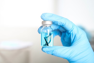 Genetics research. Scientist holding vial with liquid and illustration of DNA structure, closeup