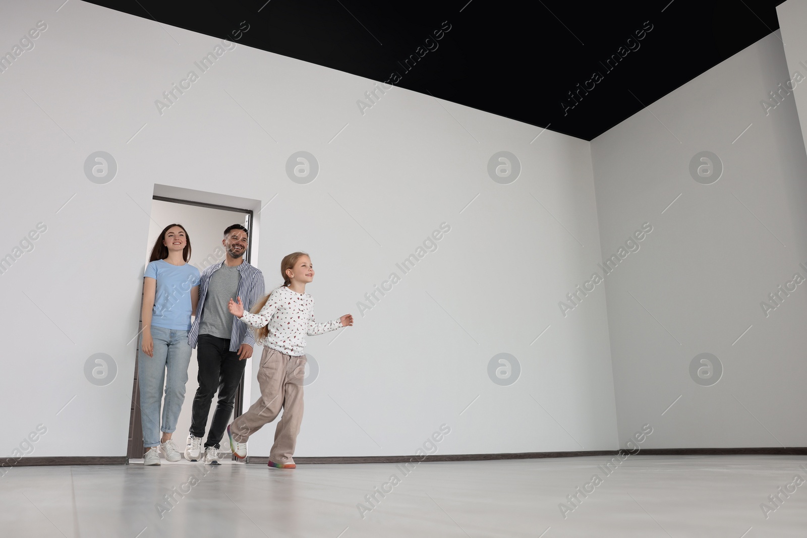 Photo of Happy family entering in their new apartment on moving day, low angle view. Space for text