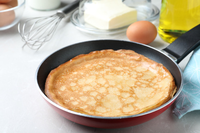 Photo of Delicious thin pancakes on grey marble table, closeup