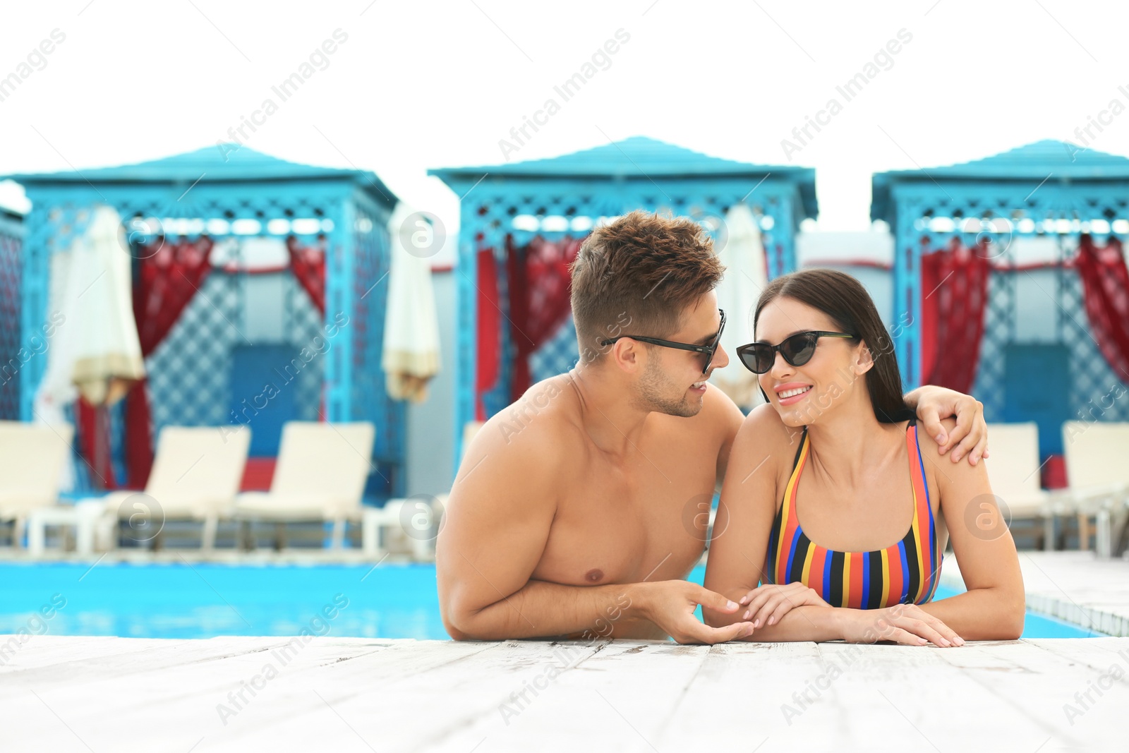 Photo of Woman in bikini with boyfriend at resort. Happy young couple