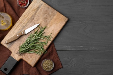 Wooden board, knife and spices on grey table, flat lay. Space for text