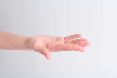 Woman holding hand on white background, closeup