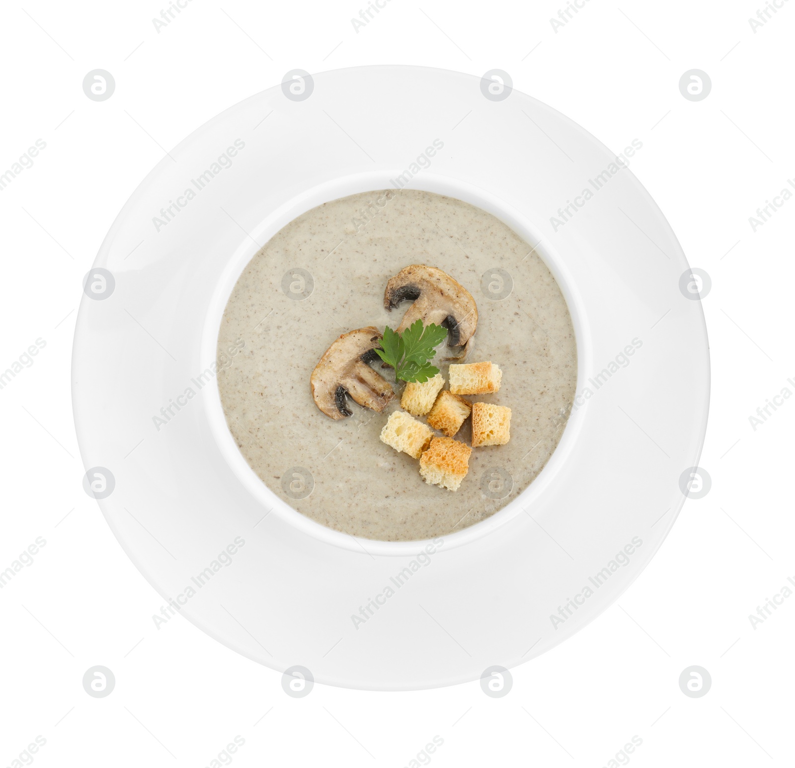 Photo of Delicious mushroom cream soup with croutons in bowl isolated on white, top view