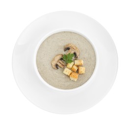 Photo of Delicious mushroom cream soup with croutons in bowl isolated on white, top view