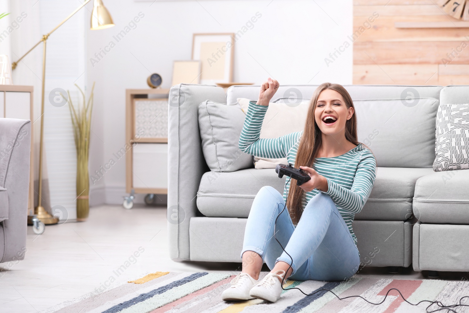 Photo of Emotional young woman playing video games at home