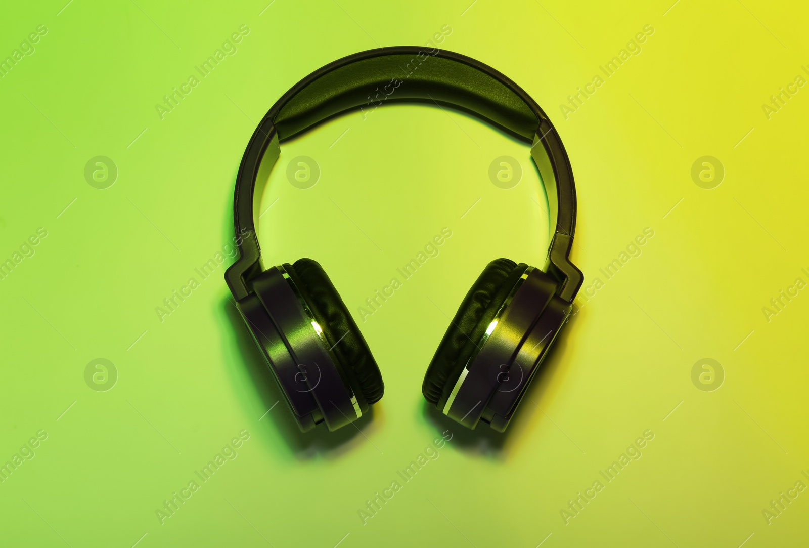 Photo of Stylish headphones on color background, top view