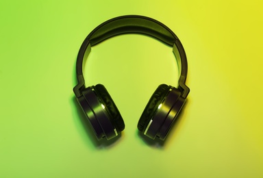 Stylish headphones on color background, top view