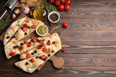 Photo of Flat lay composition with focaccia bread on wooden table. Space for text