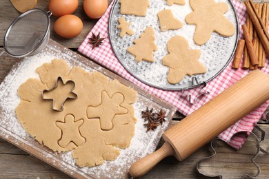 Photo of Making Christmas cookies. Flat lay composition with ingredients and raw dough on wooden table