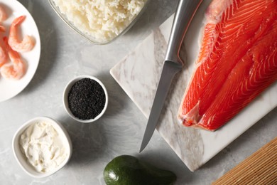 Flat lay composition with ingredients for sushi on grey marble table