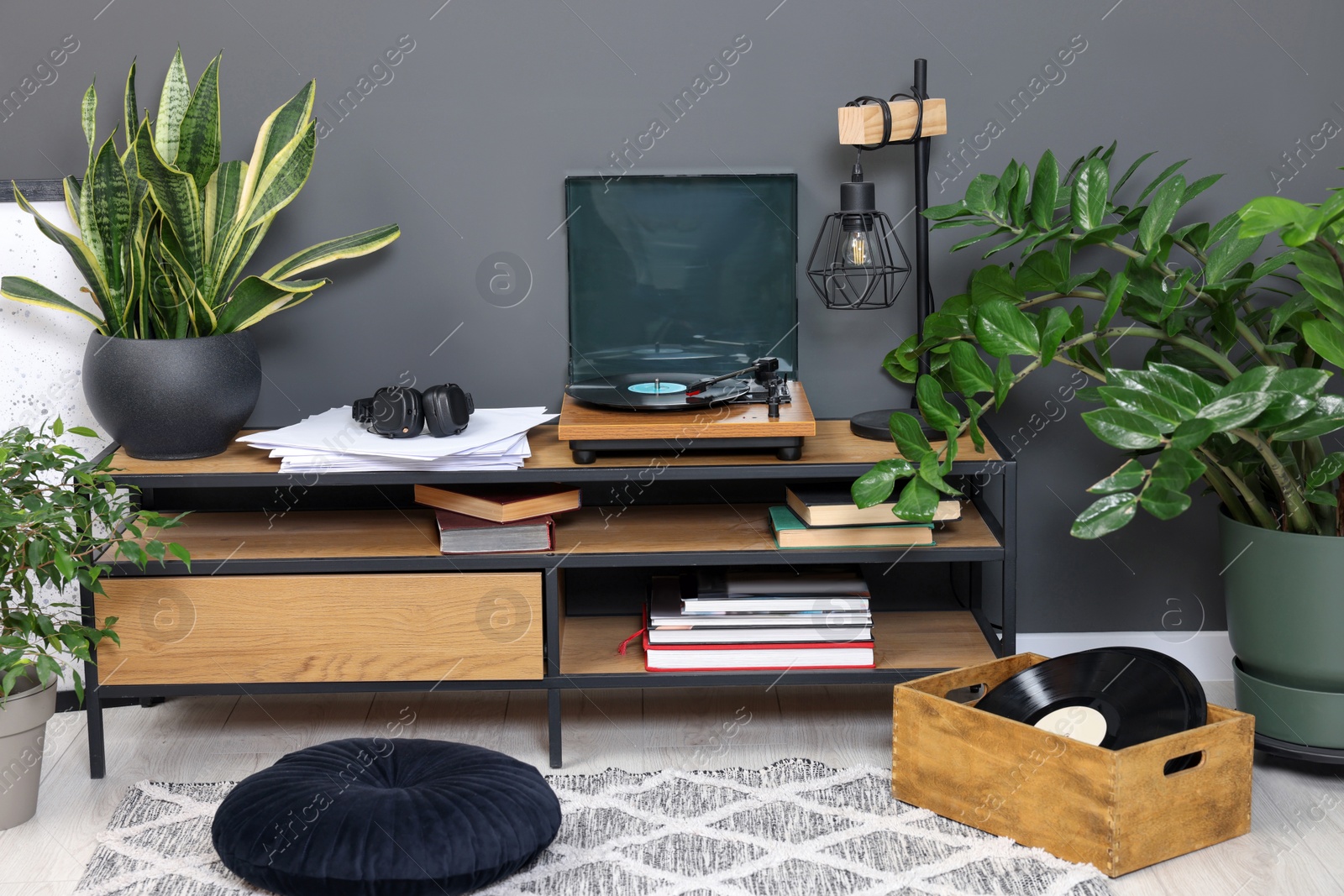 Photo of Stylish turntable with vinyl record on tv table in cozy room