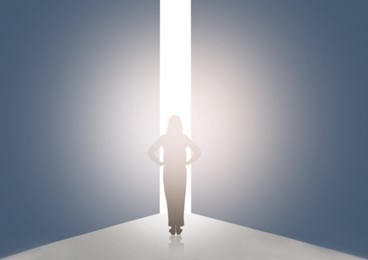 Image of Silhouette of woman standing in front of light hole, back view