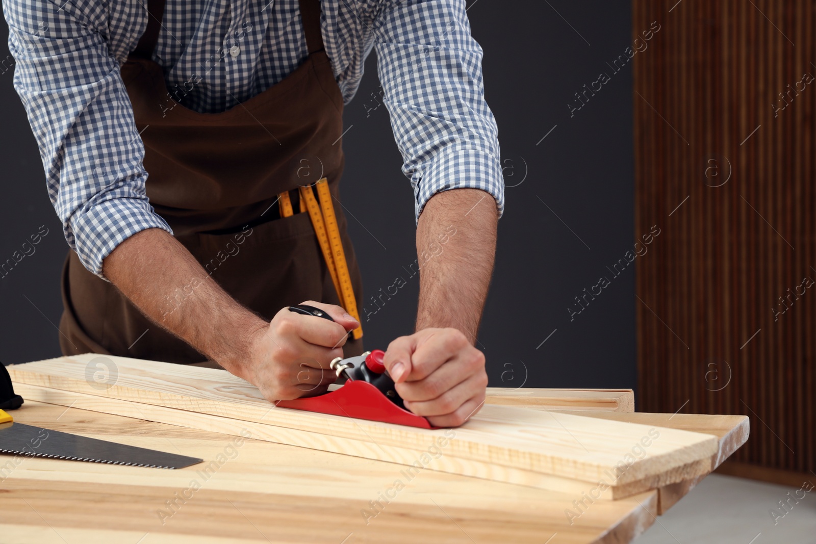 Photo of Carpenter working with timber at table indoors, closeup