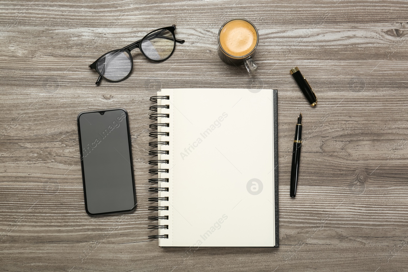 Photo of Flat lay composition with notebook and smartphone on wooden table