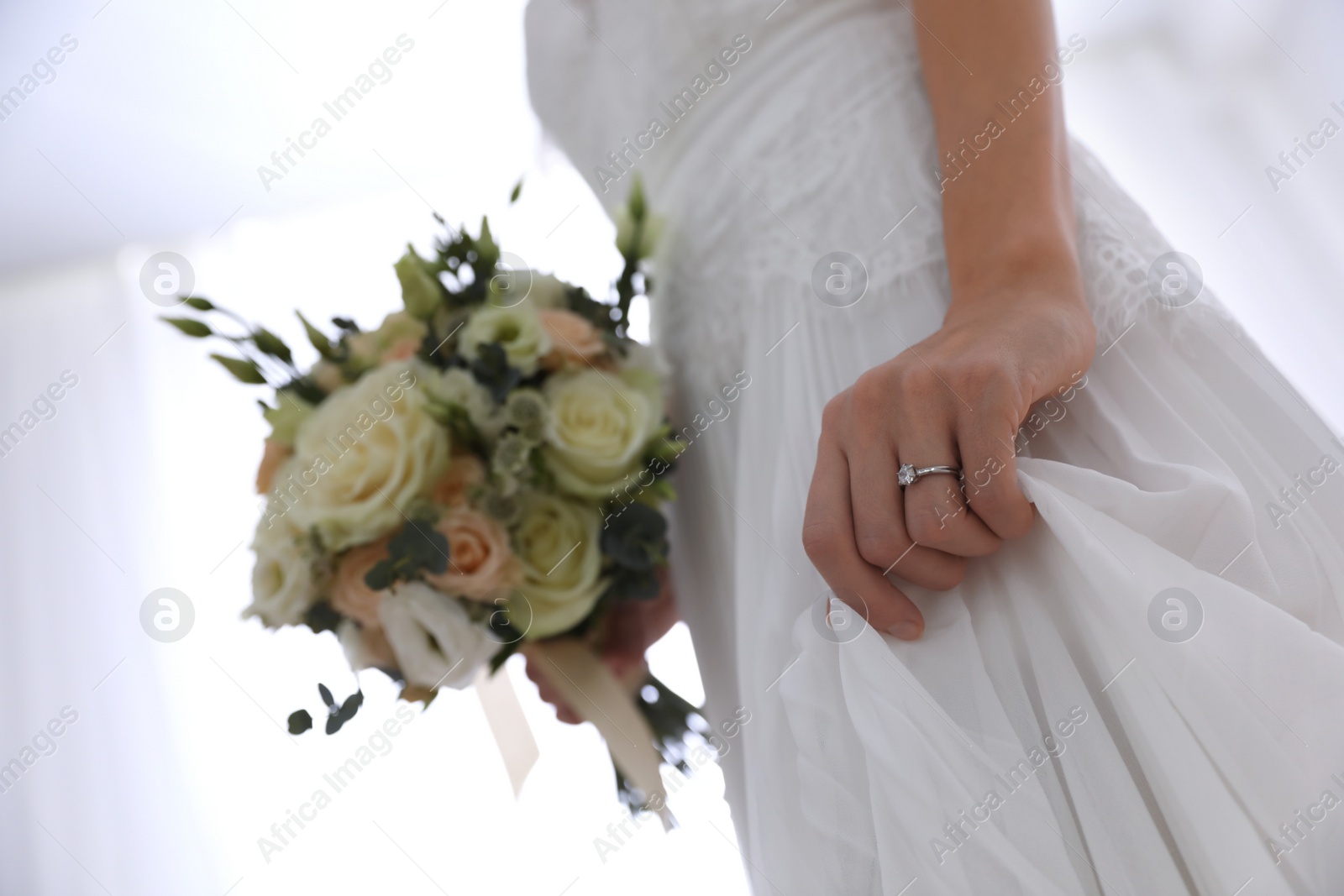 Photo of Young bride with beautiful wedding bouquet on light background, closeup