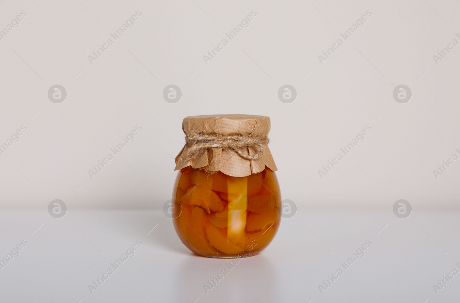 Photo of Tasty canned sliced apricots on white background