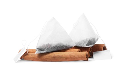 Tea bags and cinnamon sticks on white background