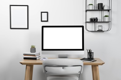 Photo of Cozy workspace with computer and stationery on wooden desk at home