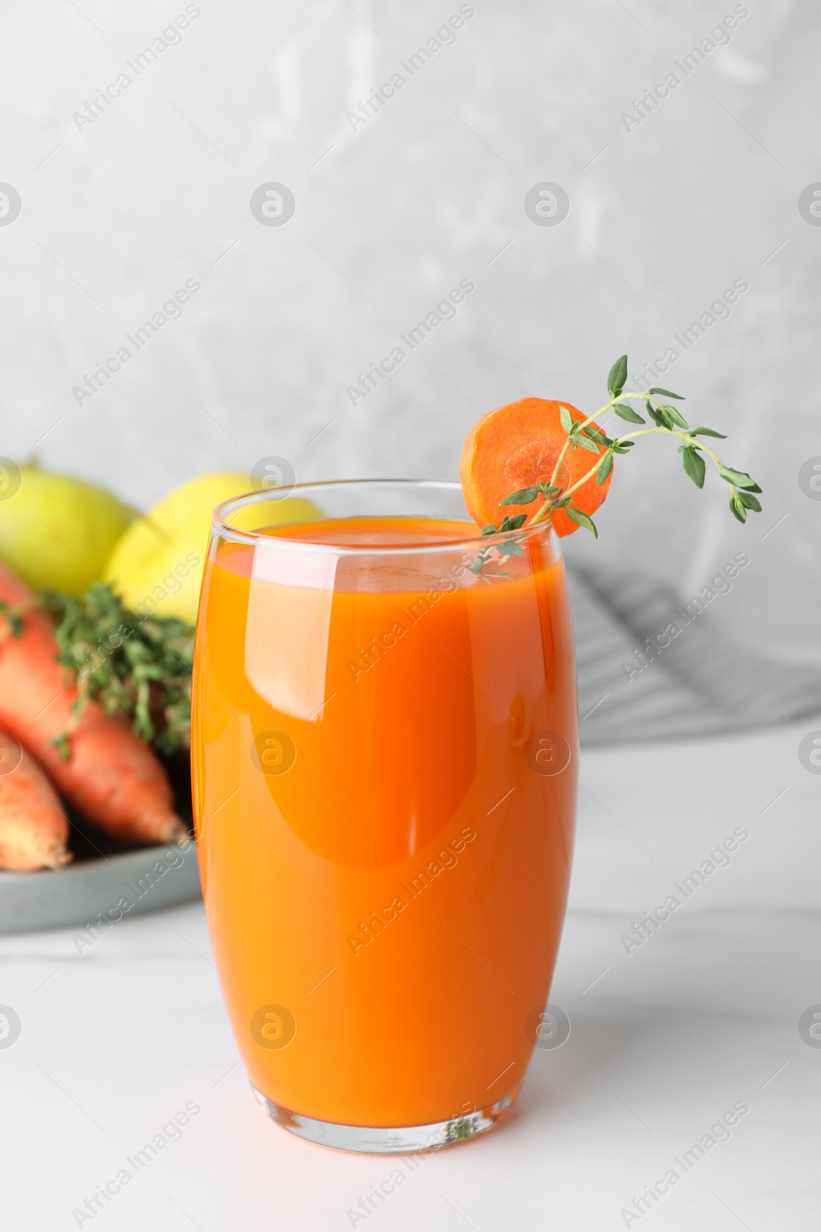 Photo of Glass with healthy carrot juice and ingredients on white table