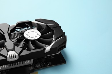 Computer graphics card on light blue background, closeup. Space for text