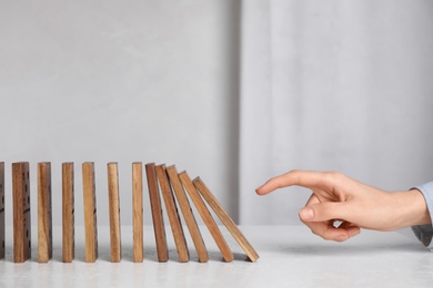 Photo of Woman with wooden dominoes at white table, closeup