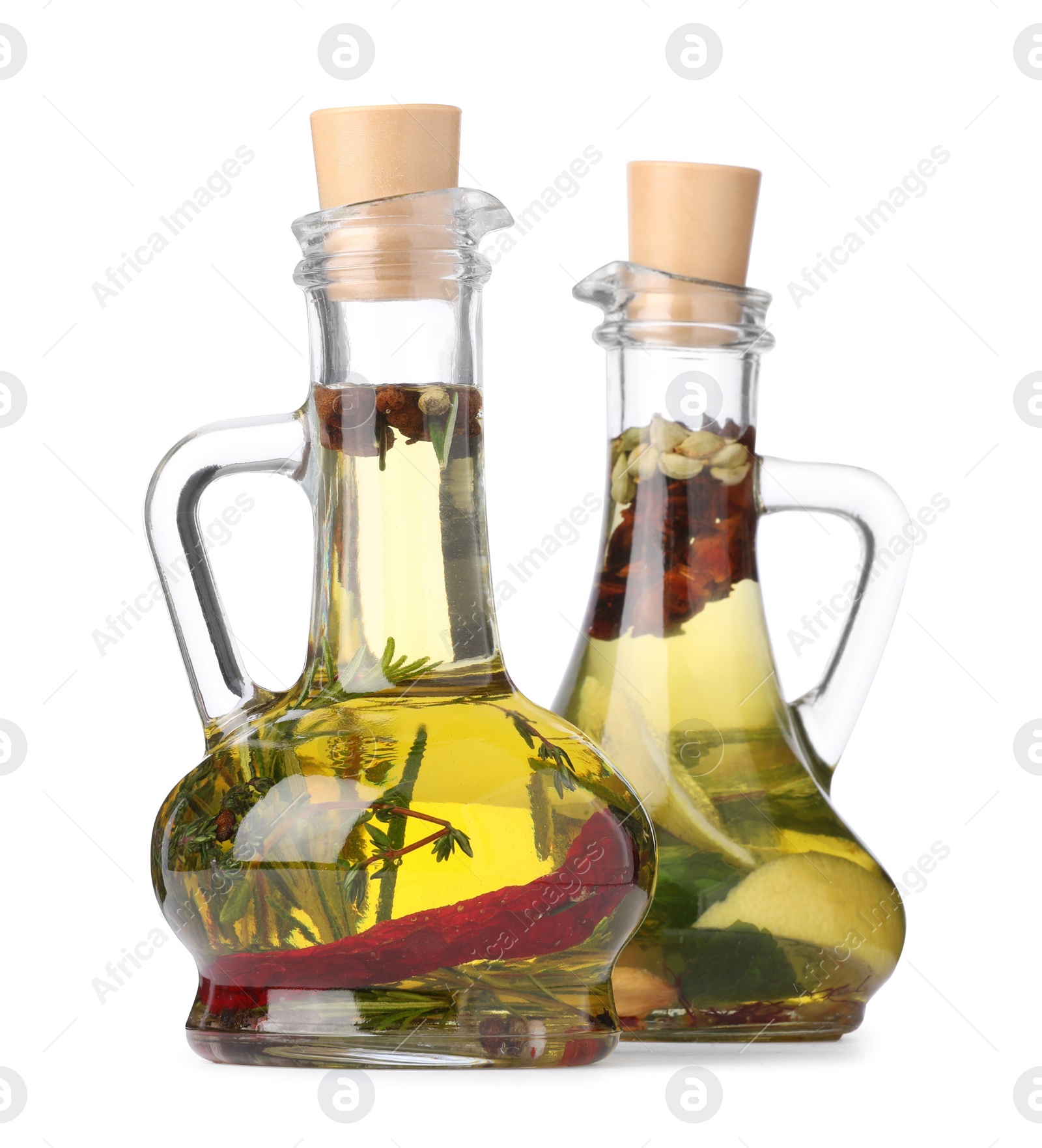 Photo of Glass jugs of cooking oils with spices and herbs on white background