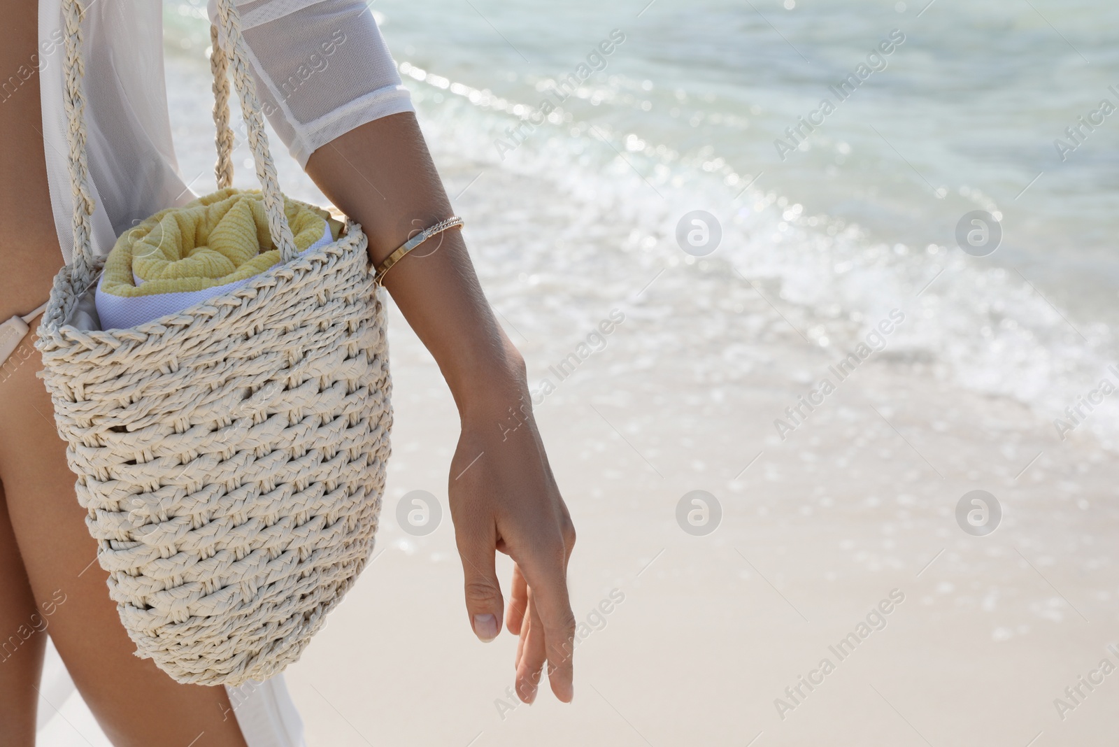 Photo of Woman with beach bag near sea, closeup