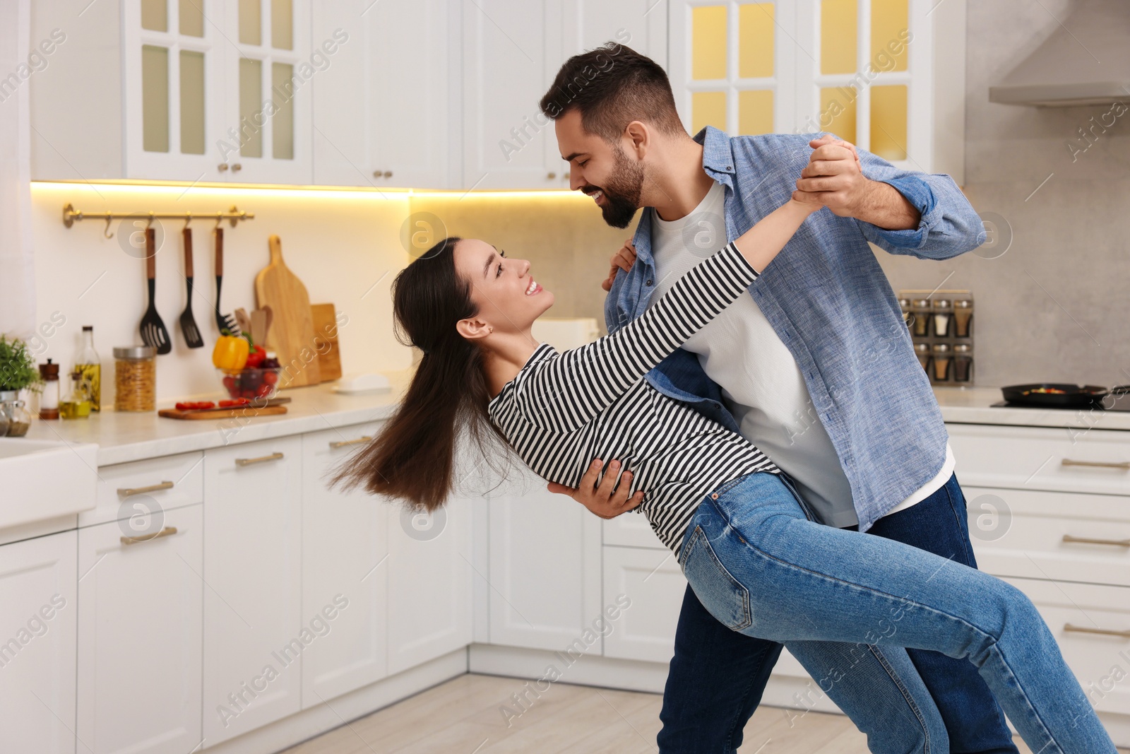 Photo of Happy lovely couple dancing together in kitchen