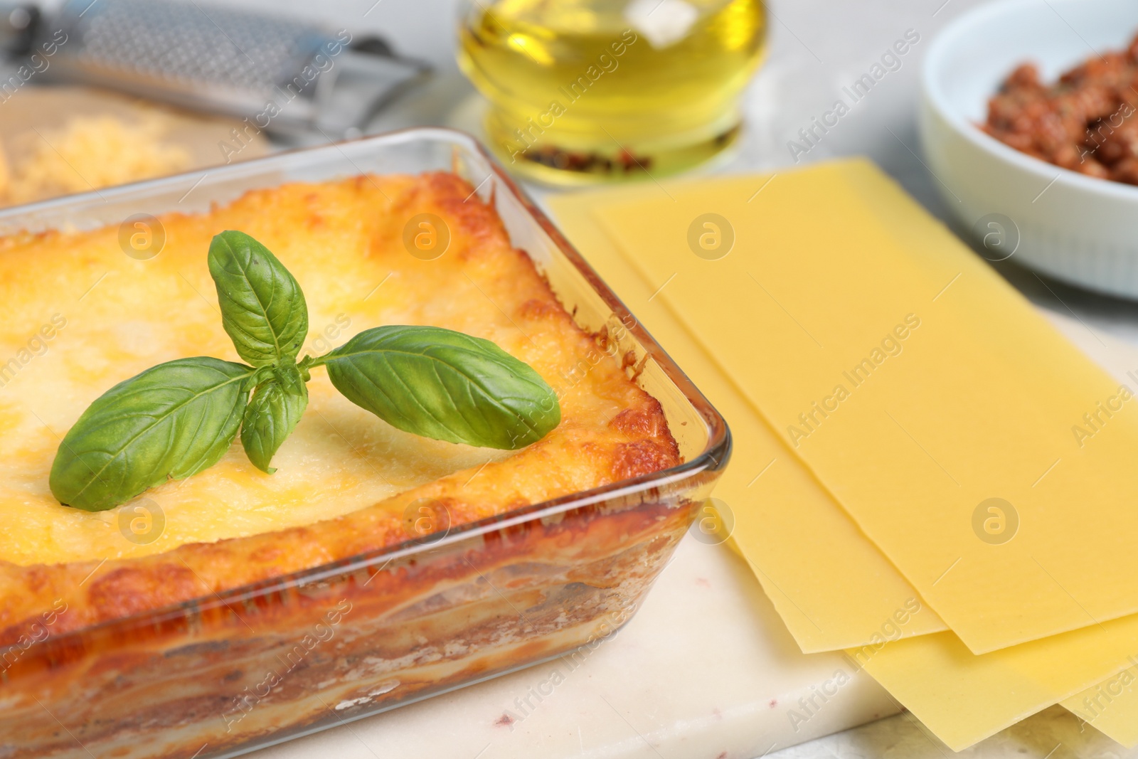 Photo of Tasty cooked lasagna in baking dish on table, closeup