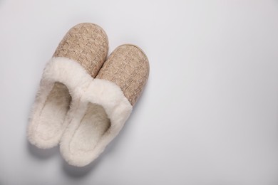 Photo of Pair of beautiful soft slippers on white background, top view. Space for text