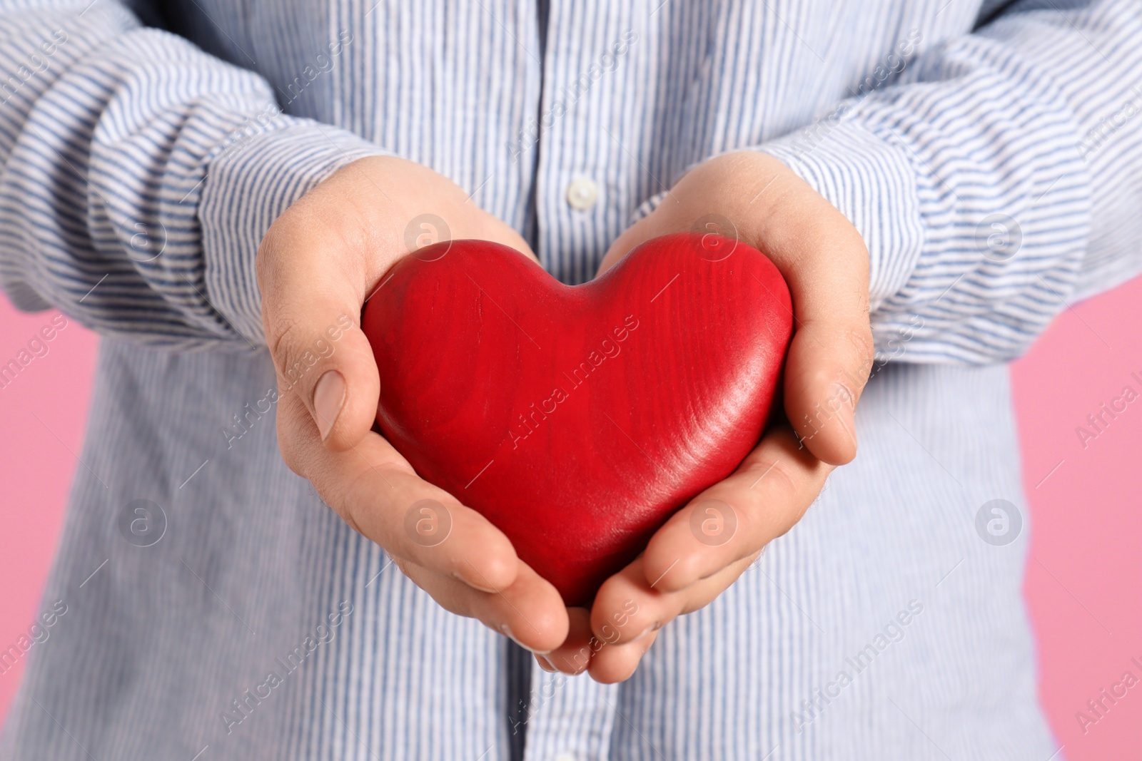 Photo of Man holding decorative heart on color background, closeup